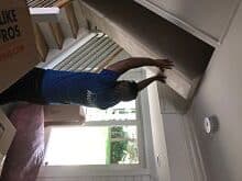 Strong Professional Mover Lifting a Box