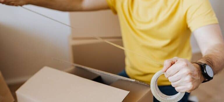 A man taping a box ready to move with movers Ridgefield CT