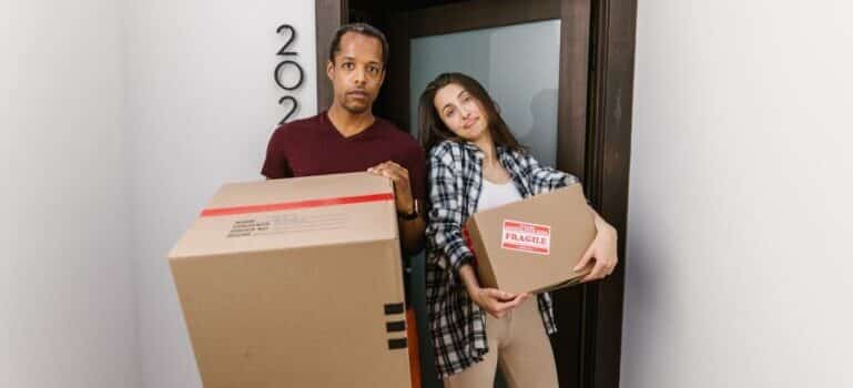 man and woman holding boxes