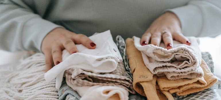 A woman stacking clothes for her Connecticut to New Jersey Movers.