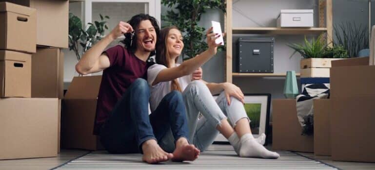 A couple taking a selfie after moving into their new home with movers Guilford CT