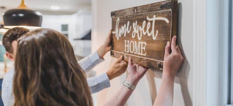 A couple holding wooden decoration after moving to Fairfield