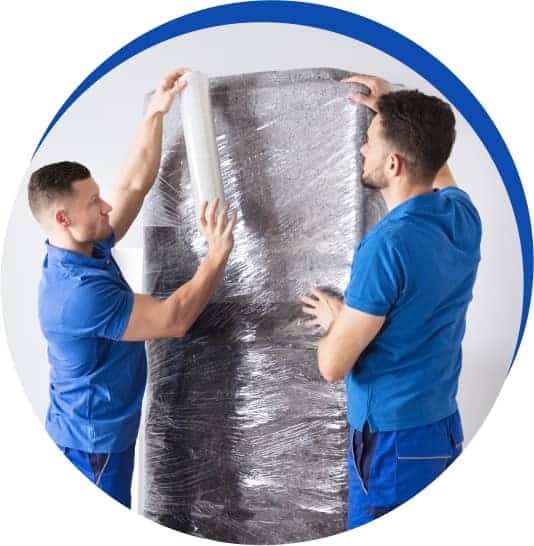 Two professional packers wrapping furniture for a move
