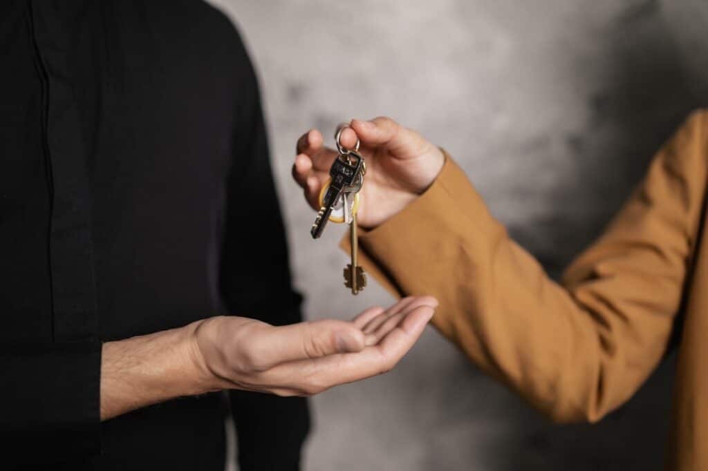A Person Giving a Bundle of Keys to another Person
