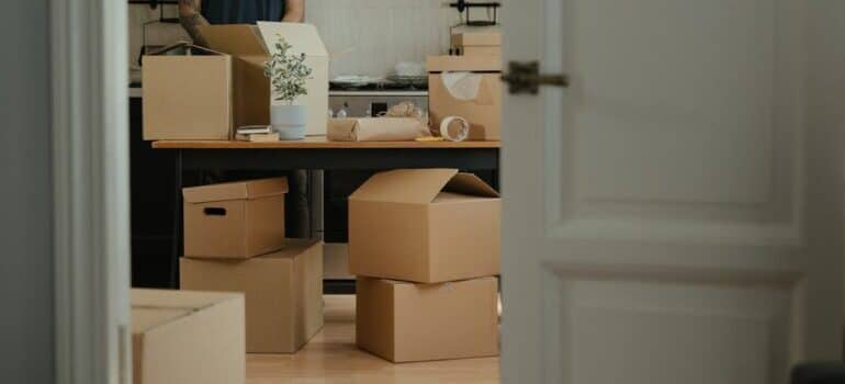 Man in Black Shirt Standing Near Brown Cardboard Boxes