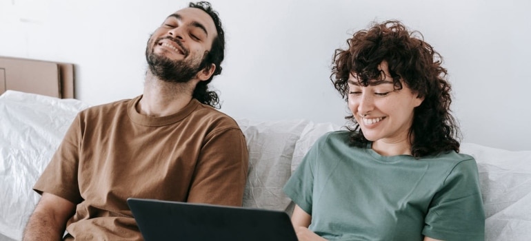 Couple looking at a laptop and searching for best Connecticut to Rhode Island Movers