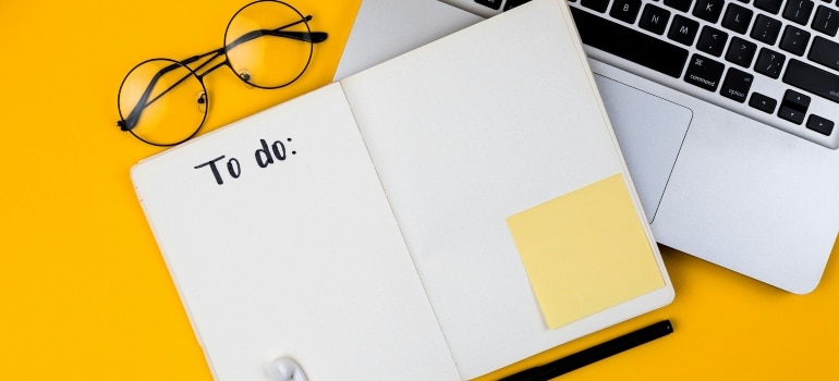 A to-do list, glasses and laptop needed for organization when you move during the busy season 