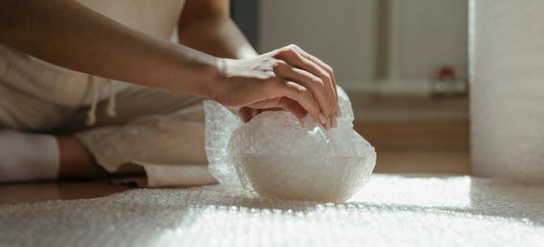 A person wrapping something before movers and packers CT come