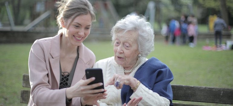 A young woman showing something to an old woman