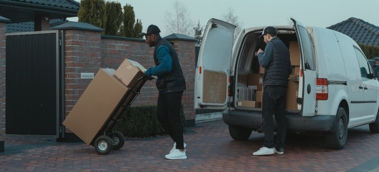 People transporting boxes to student storage units 