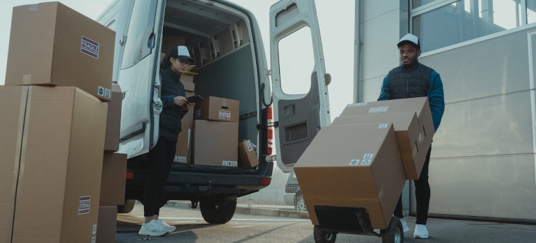 Movers loading boxes in a van 