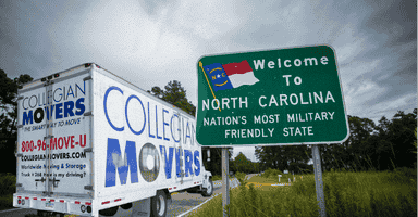 Collegian Movers truck driving past a 'Welcome to North Carolina' sign, symbolizing North Carolina relocation advice.