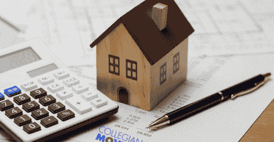 Paperwork, a calculator, and a model house representing how the cost of living in New Haven, CT, could affect your budget when considering a move to Connecticut.