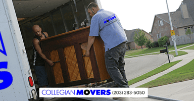 Two professional piano movers in New Haven neighborhood loading an upright piano onto a Collegian Movers moving truck.